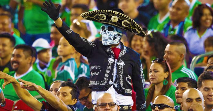 Fans mexicanos viendo el fútbol en el estadio