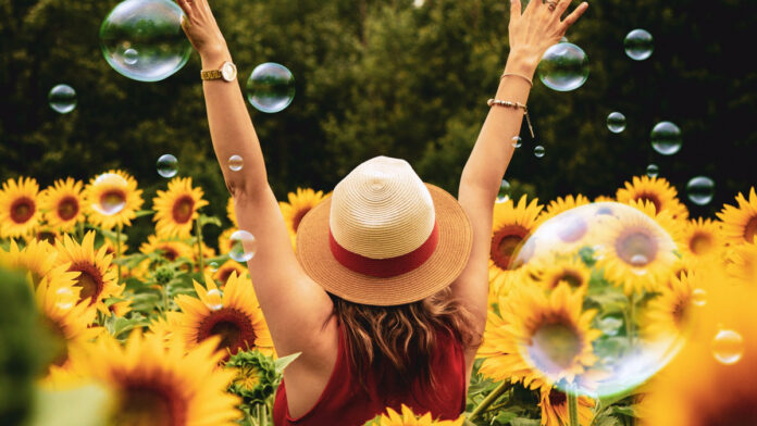 Mujer feliz en campo de flores de girasol